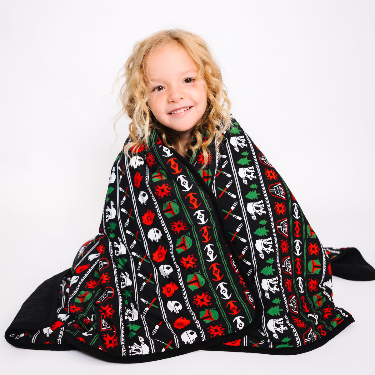 Girl wrapped in the Merry Galaxy quilted bamboo kids blanket