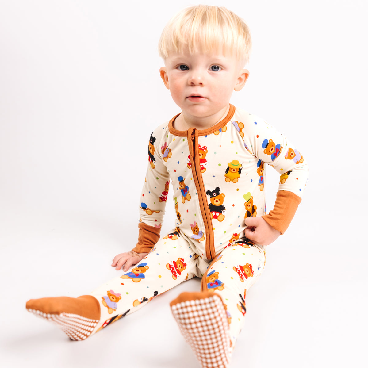 Baby sitting in the Main Street Bears bamboo convertible romper with caramel zipper trim