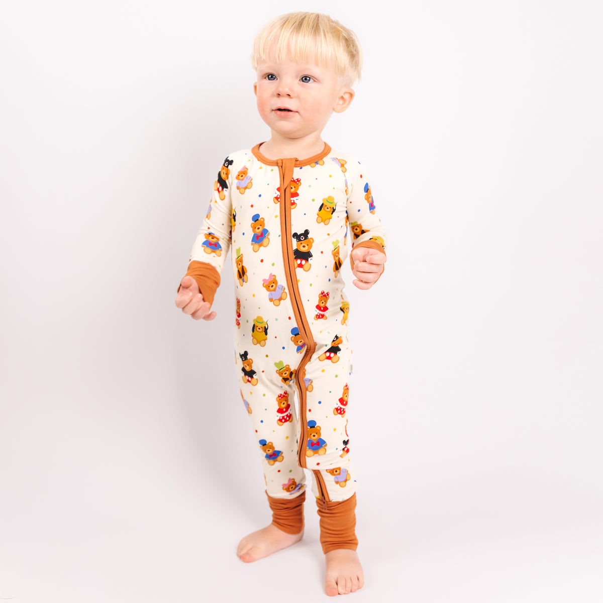 Toddler standing in the Main Street Bears convertible romper with the feet folded open