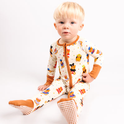 Baby sitting in the Main Street Bears bamboo convertible romper with caramel zipper trim