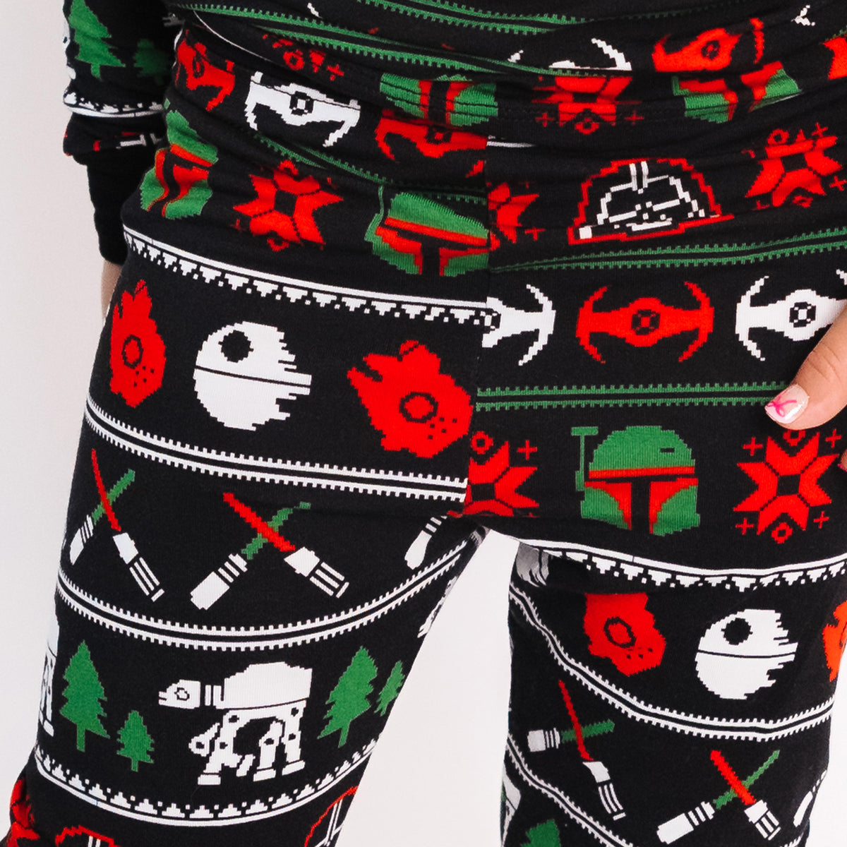 Close-up of the Merry Galaxy pajama pants in red, green and white on black