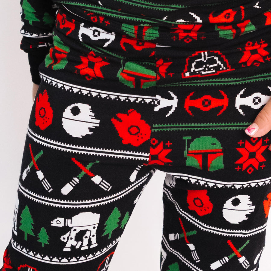 Close-up of the Merry Galaxy pajama pants in red, green and white on black